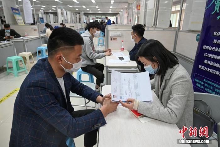4月14日，招聘者在查看求職者簡(jiǎn)歷。<a target='_blank'  data-cke-saved- >中新社</a>記者 王剛 攝