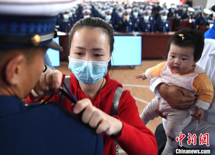 新消防員楊振的妻子彭莉與女兒現(xiàn)場見證丈夫加入“火焰藍”的神圣時刻。　劉忠俊 攝