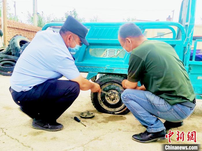 賽旦與民警共同維修三輪摩托車?！∫懒窘?攝