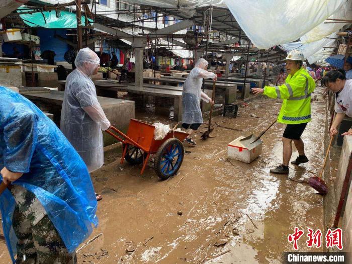 圖為7月26日，暴雨引發(fā)的洪水過(guò)境后，重慶萬(wàn)州區(qū)分水鎮(zhèn)政府干部職工及志愿者清掃淤泥和垃圾。　　重慶萬(wàn)州區(qū)委宣傳部供圖 攝