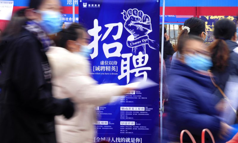 求職者從一家招聘企業(yè)的廣告牌前走過。新華社發(fā)（苑立偉 攝）