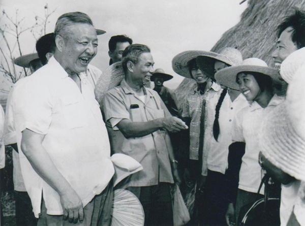 1980年8月底至9月初，習(xí)仲勛（左一）在廣東湛江農(nóng)村視察時(shí)與青年親切交談。