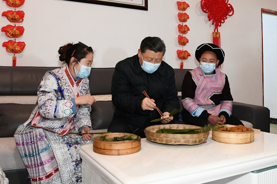 2021年2月3日下午，習(xí)近平在貴州畢節(jié)市黔西縣新仁苗族鄉(xiāng)化屋村苗族村民趙玉學(xué)家，同一家人邊聊家常邊制作當(dāng)?shù)貍鹘y(tǒng)節(jié)日食品黃粑。新華社記者 李學(xué)仁 攝